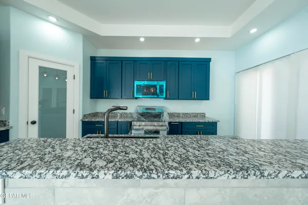 a bathroom with a granite countertop sink a mirror and shower