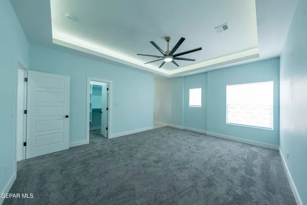 an empty room with ceiling fan and window