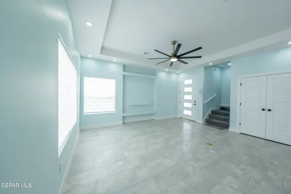 an empty room with a ceiling fan and a shower