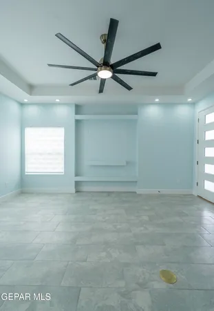 an empty room with a window and a fan