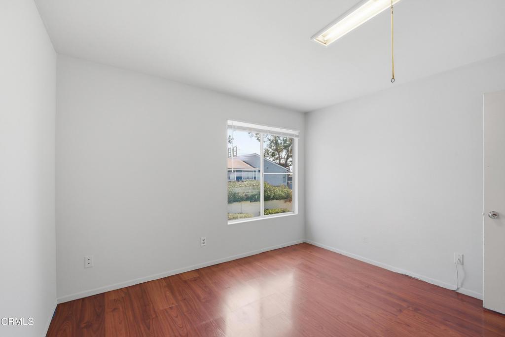 5154 Jefferson Square Oxnard, CA 93033 - Photo 18 of 23 an empty room with wooden floor and windows