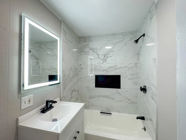 a bathroom with a sink a mirror and a bathtub