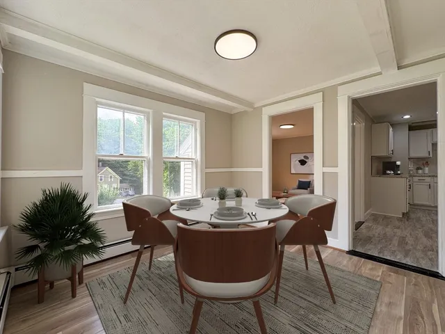 a dining room with furniture window and wooden floor