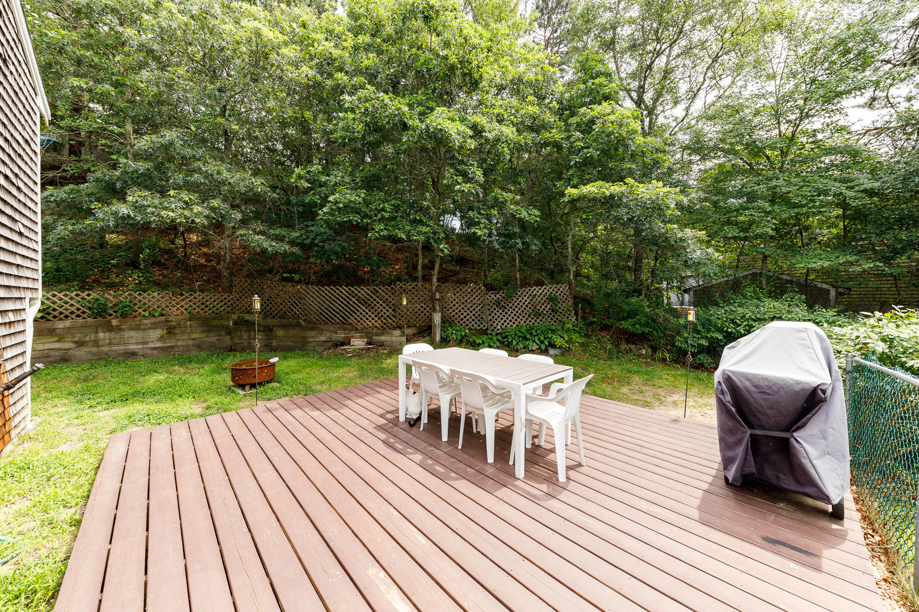 104 Valley Bars Road Bourne, MA 02532 - Photo 5 of 22 a view of a chairs and table on the wooden deck