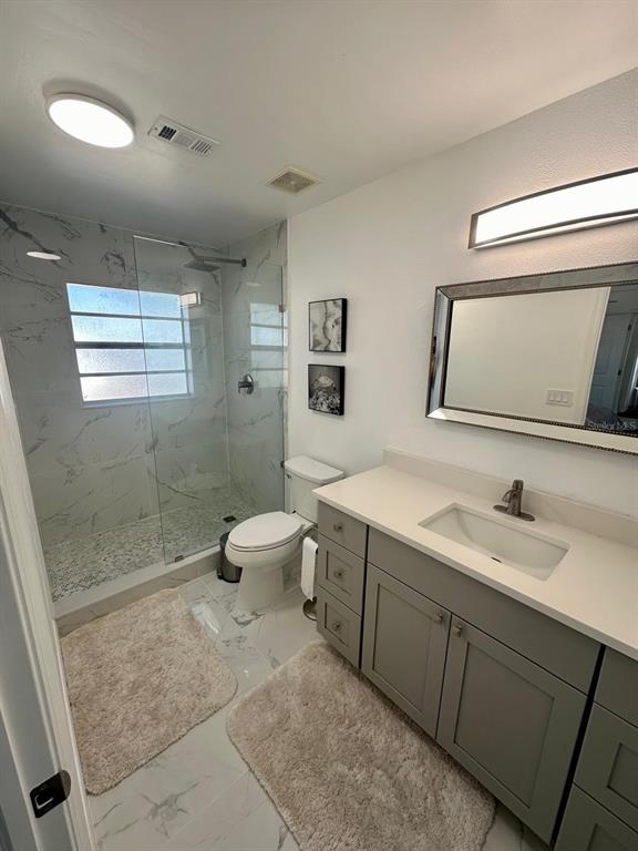 13272 Helm Street Largo, FL 33774 - Photo 11 of 20 a spacious bathroom with a toilet sink and mirror