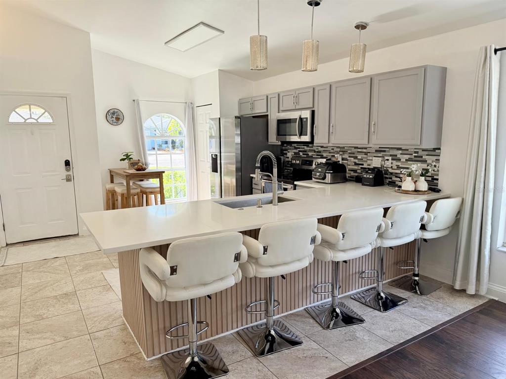 13272 Helm Street Largo, FL 33774 - Photo 2 of 20 a kitchen with a sink a counter and chairs