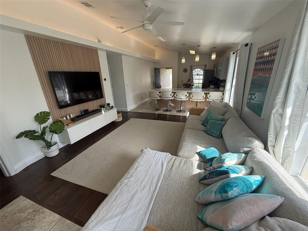 13272 Helm Street Largo, FL 33774 - Photo 5 of 20 a living room with furniture potted plant a flat screen tv and a fireplace