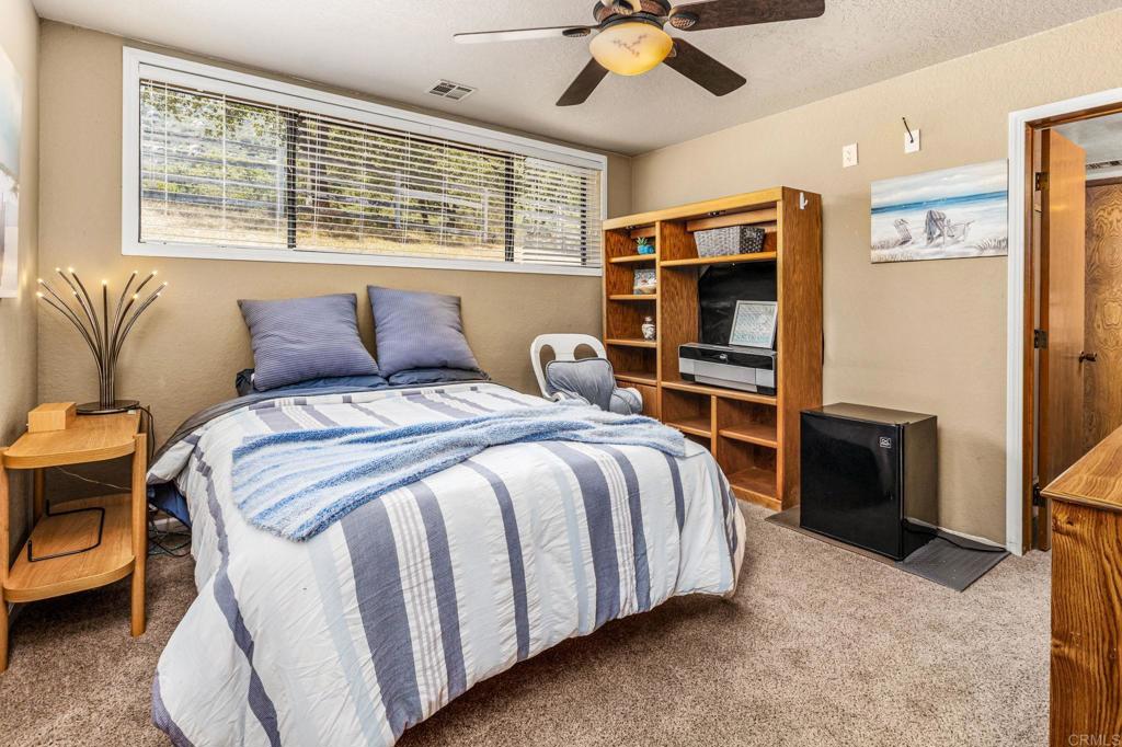 17901 Lyons Valley Road Jamul, CA 91935 - Photo 21 of 52 a bedroom with a bed and a chandelier