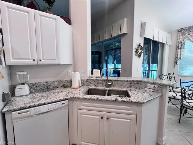 a kitchen with granite countertop a sink a stove and cabinets