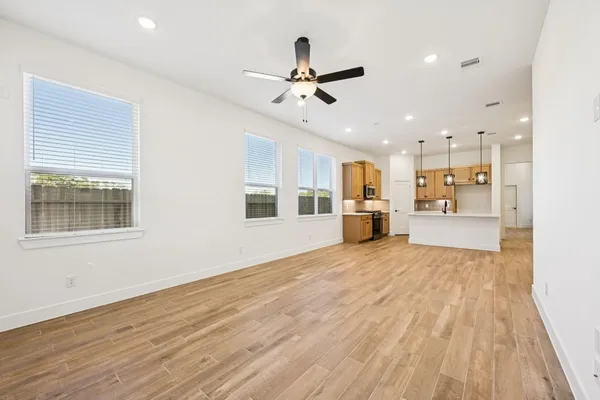 a view of an empty room with window and wooden floor
