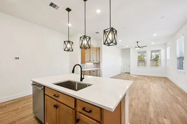 a kitchen with stainless steel appliances granite countertop a sink a stove and a wooden floors
