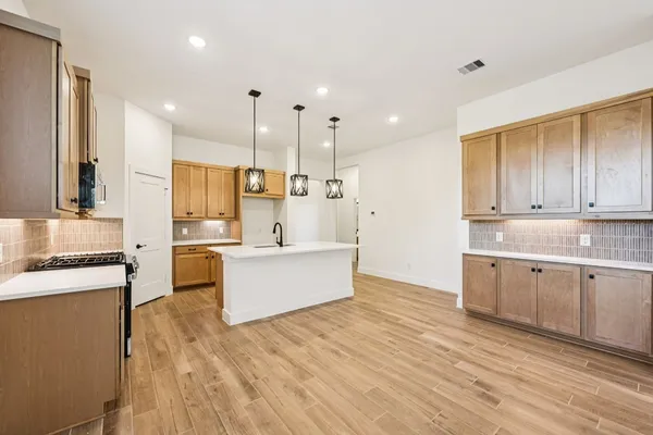 a kitchen with stainless steel appliances granite countertop a sink a stove and a refrigerator