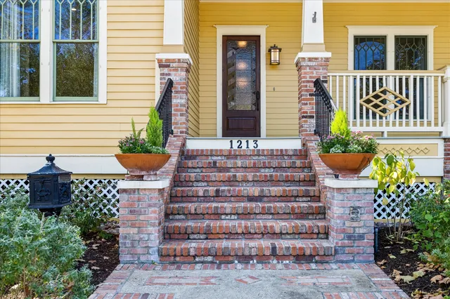 a front view of a house with potted plants