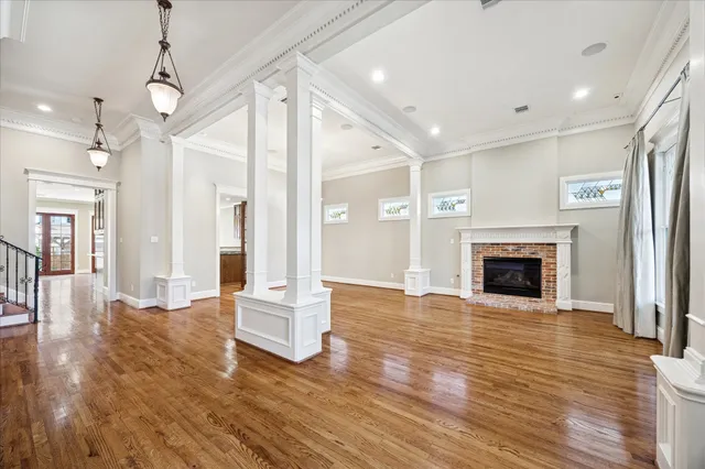 a view of a big room with wooden floor and a kitchen
