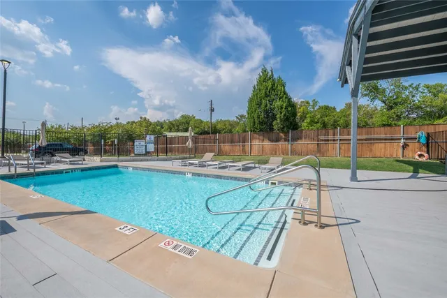 a view of a swimming pool with a patio and a yard