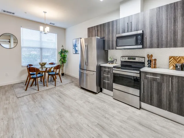 a kitchen with granite countertop a refrigerator and a stove top oven
