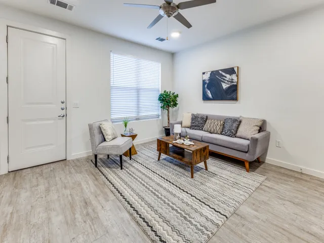 a living room with furniture and a wooden floor