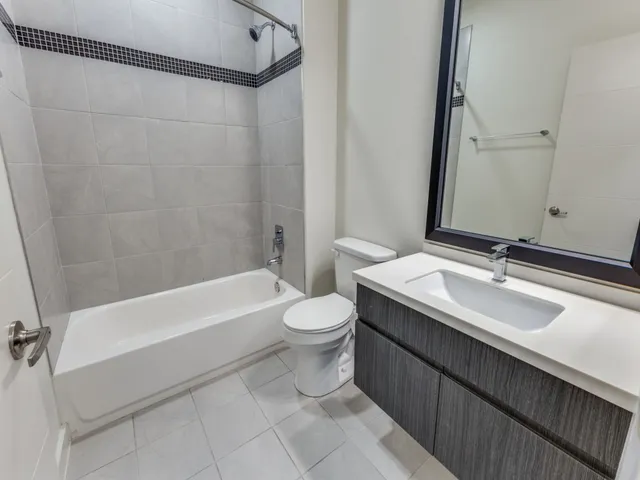 a bathroom with a double vanity sink toilet and shower