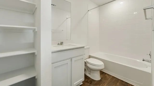 a view of an empty room with closet and a window