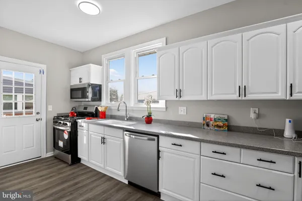 a kitchen with stainless steel appliances granite countertop a sink and cabinets