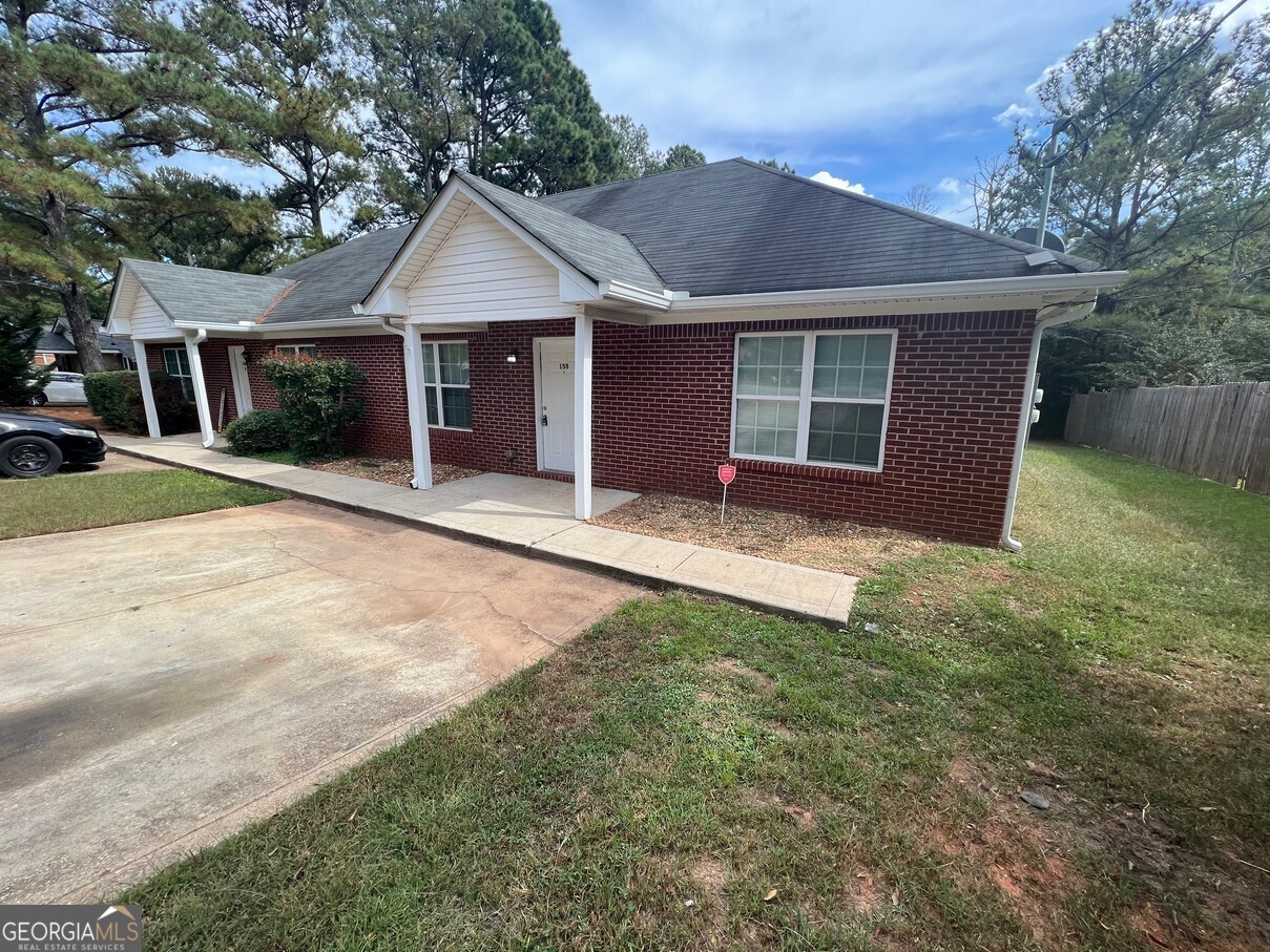 158 Elder Drive Southeast, Unit B Social Circle, GA 30025 - Photo 1 of 19 a front view of a house with a garden and yard