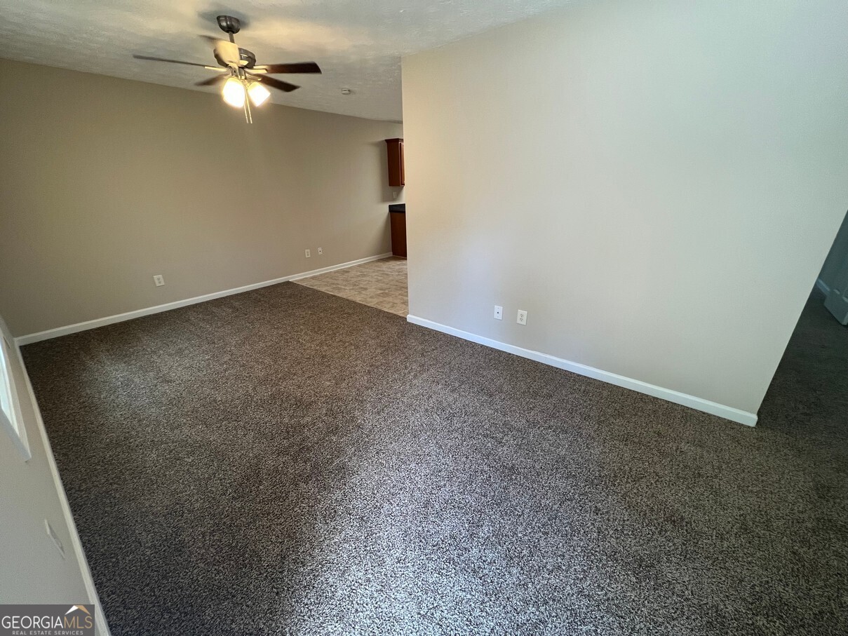 158 Elder Drive Southeast, Unit B Social Circle, GA 30025 - Photo 5 of 19 an empty room with a fan & a ceiling fan