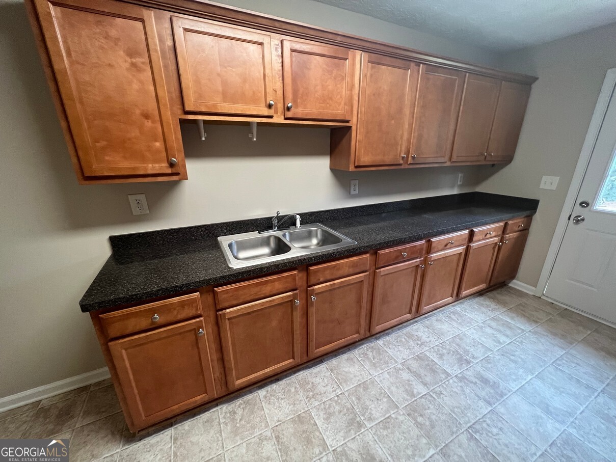 158 Elder Drive Southeast, Unit B Social Circle, GA 30025 - Photo 8 of 19 a kitchen with stainless steel appliances granite countertop wooden cabinets and a sink