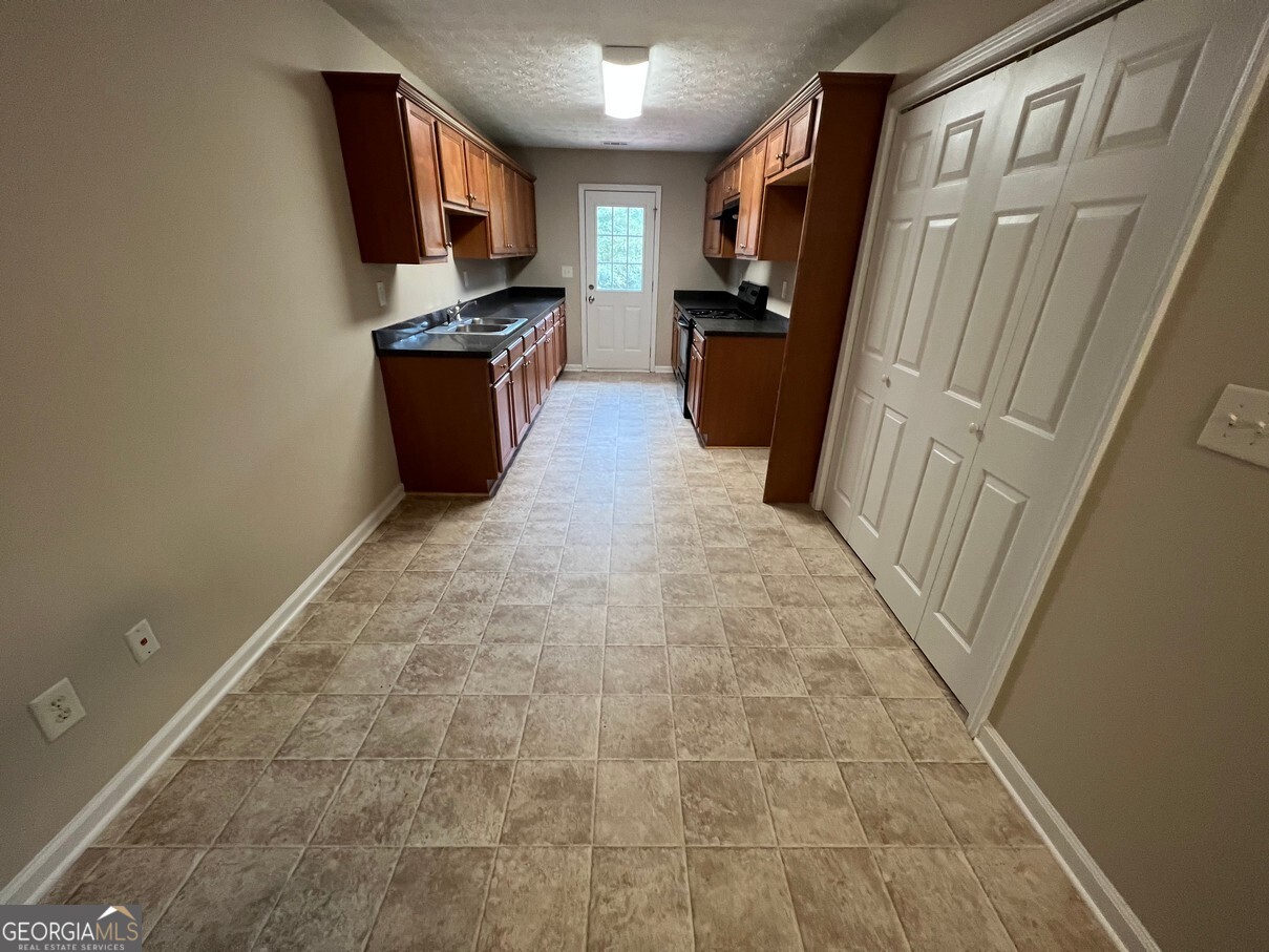 158 Elder Drive Southeast, Unit B Social Circle, GA 30025 - Photo 9 of 19 a kitchen with a refrigerator stove and a sink