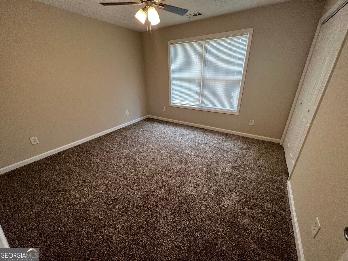 158 Elder Drive Southeast, Unit B Social Circle, GA 30025 - Photo 10 of 19 an empty room with windows and fan