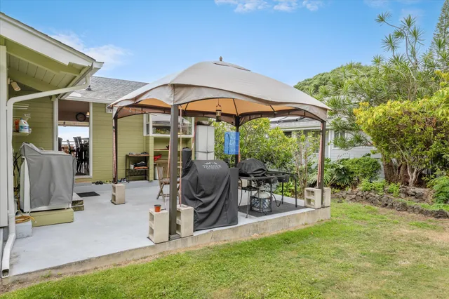 a view of a chair and table in the patio next to a yard