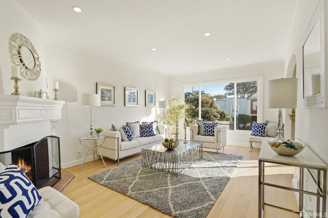 a living room with furniture chandelier and rug