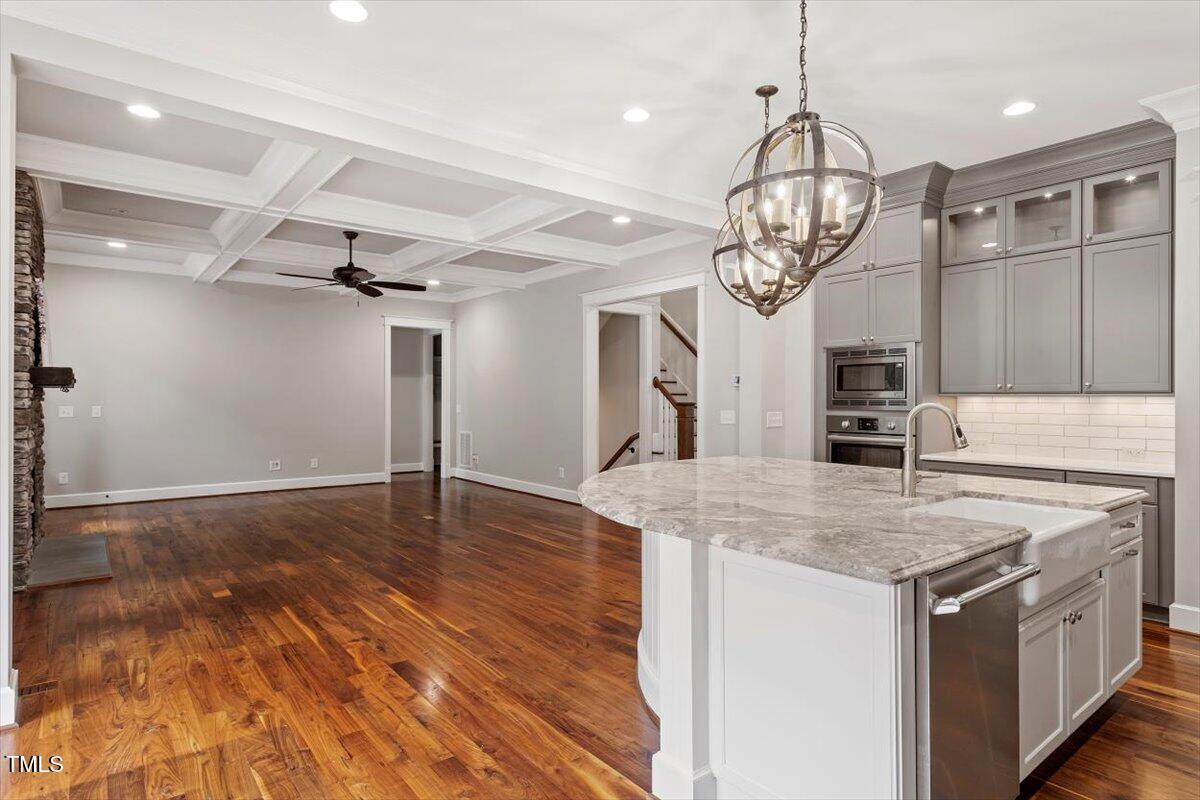 612 Hawks Ridge Court Apex, NC 27539 - Photo 13 of 58 a kitchen with kitchen island granite countertop a stove and a wooden floors