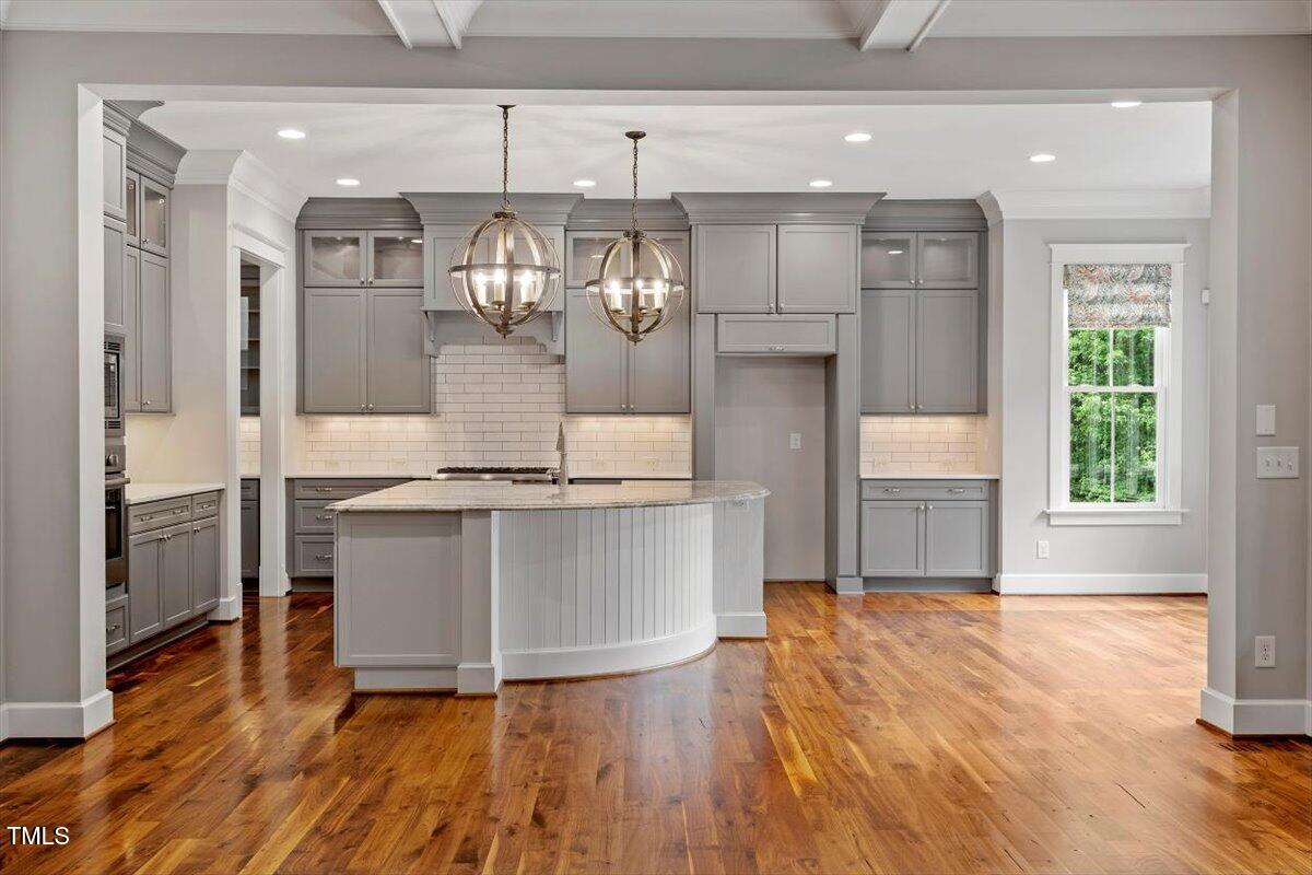 612 Hawks Ridge Court Apex, NC 27539 - Photo 15 of 58 a kitchen with kitchen island granite countertop a sink cabinets and wooden floor