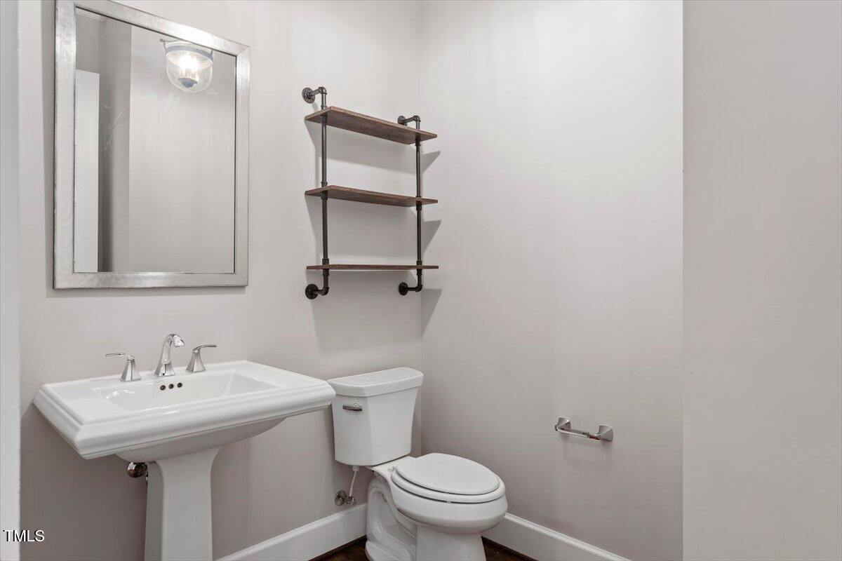 612 Hawks Ridge Court Apex, NC 27539 - Photo 36 of 58 a bathroom with a sink toilet and mirror