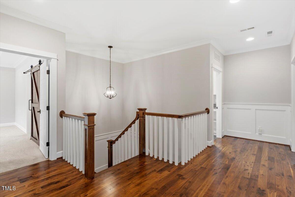 612 Hawks Ridge Court Apex, NC 27539 - Photo 37 of 58 a view of a hallway with wooden floor and stairs