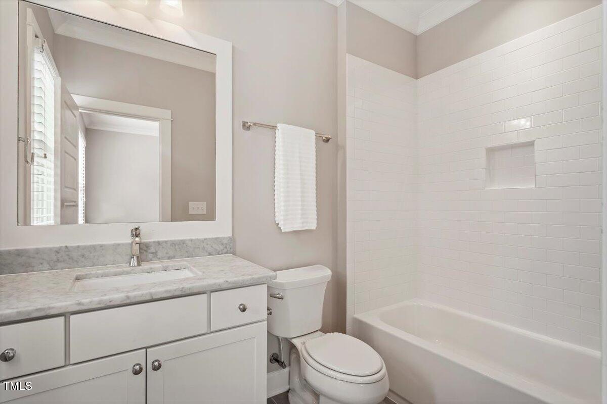 612 Hawks Ridge Court Apex, NC 27539 - Photo 41 of 58 a bathroom with a granite countertop toilet a sink and a bathtub
