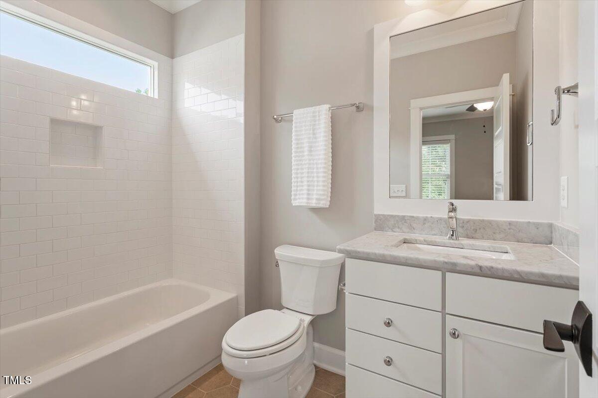 612 Hawks Ridge Court Apex, NC 27539 - Photo 49 of 58 a bathroom with a granite countertop toilet a sink and a bathtub