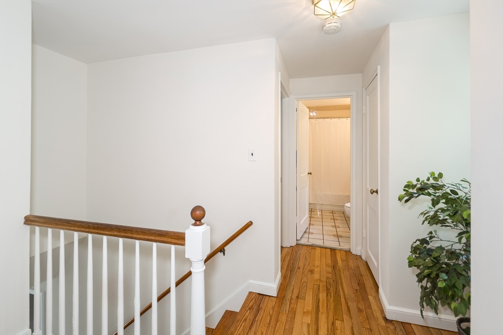 16 Surrey Lane Natick, MA 01760 - Photo 15 of 28 a view of a hallway with wooden floor and staircase