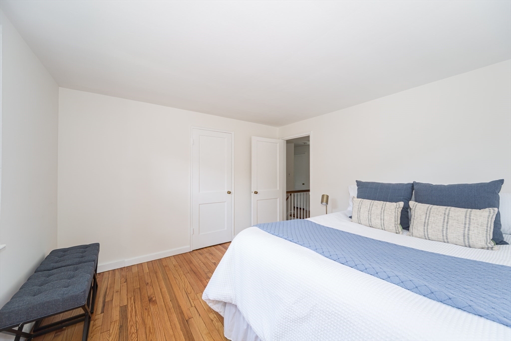 16 Surrey Lane Natick, MA 01760 - Photo 19 of 28 a bedroom with a bed and wooden floor