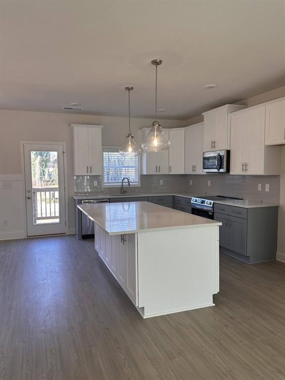 814 Glennferry Bend Southwest Mableton, GA 30126 - Photo 5 of 33 a large kitchen with stainless steel appliances kitchen island granite countertop wooden floors and a view of living room
