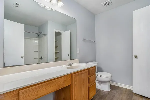 a bathroom with a granite countertop sink a toilet and a mirror