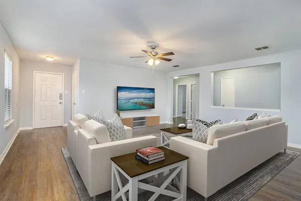 a living room with furniture and a wooden floor