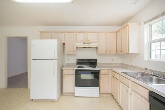 a kitchen with a stove a refrigerator and a sink