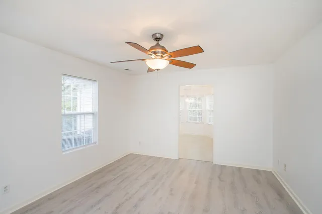 an empty room with fan and windows