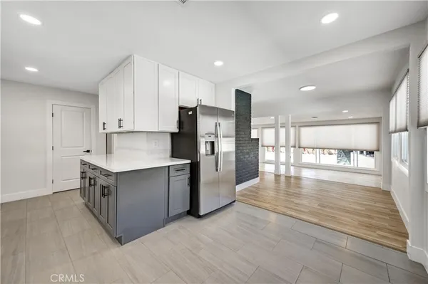 a kitchen with stainless steel appliances granite countertop a refrigerator a stove and a wooden floors