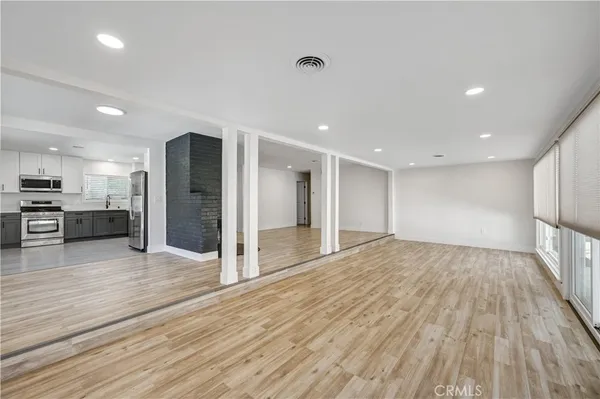 a view of an empty room with wooden floor