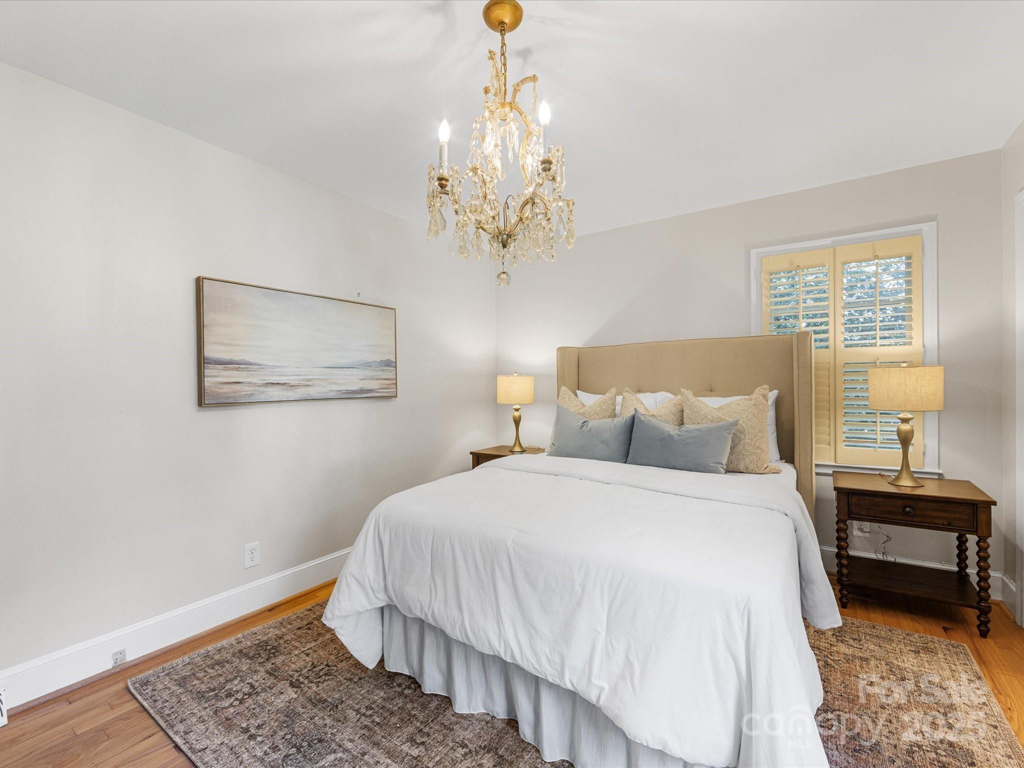 2118 Sharon Road Charlotte, NC 28207 - Photo 29 of 48 a bedroom with a bed and a chandelier