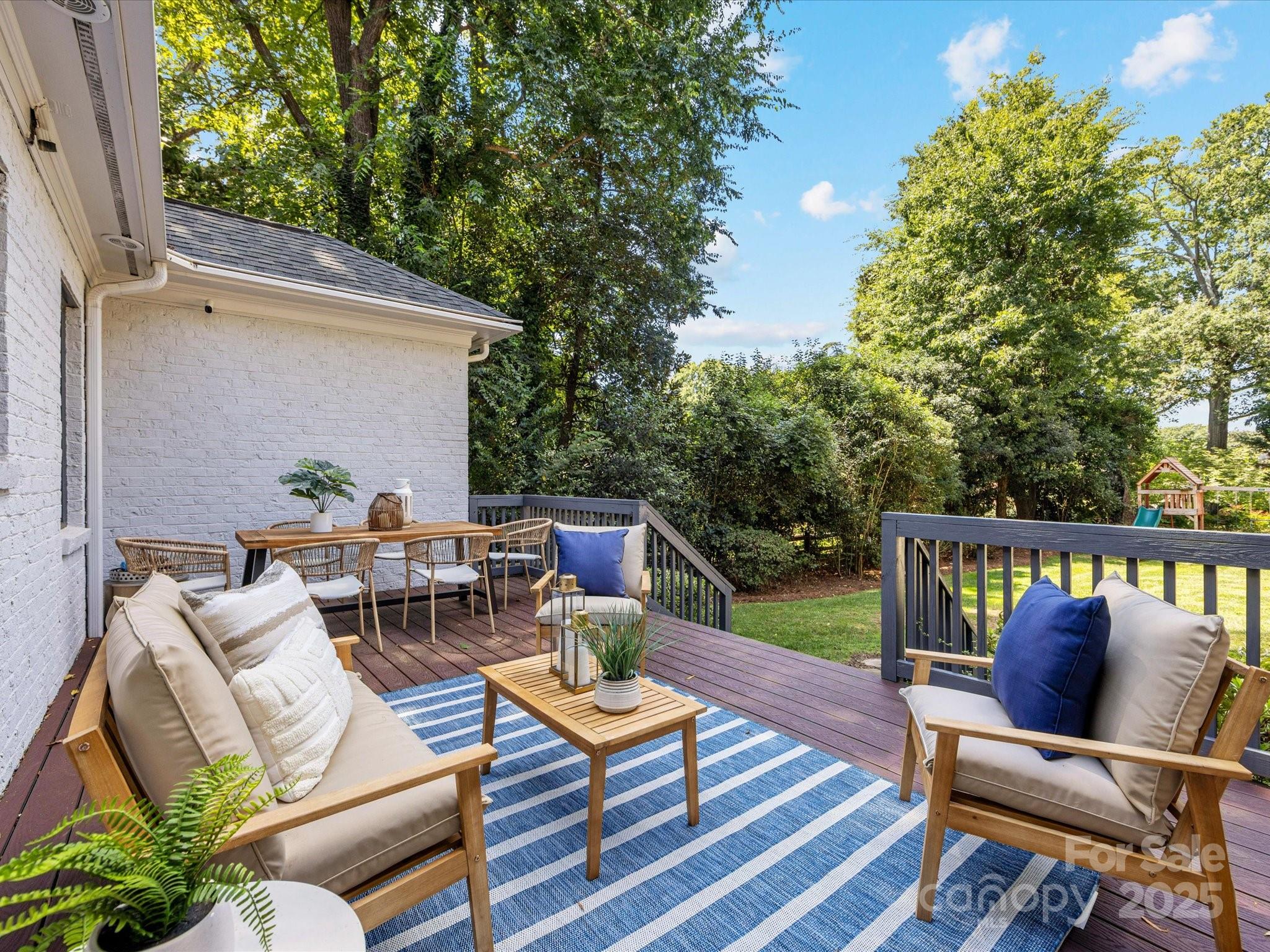 2118 Sharon Road Charlotte, NC 28207 - Photo 43 of 48 a view of a patio with couches and a table and chairs with wooden floor and fence