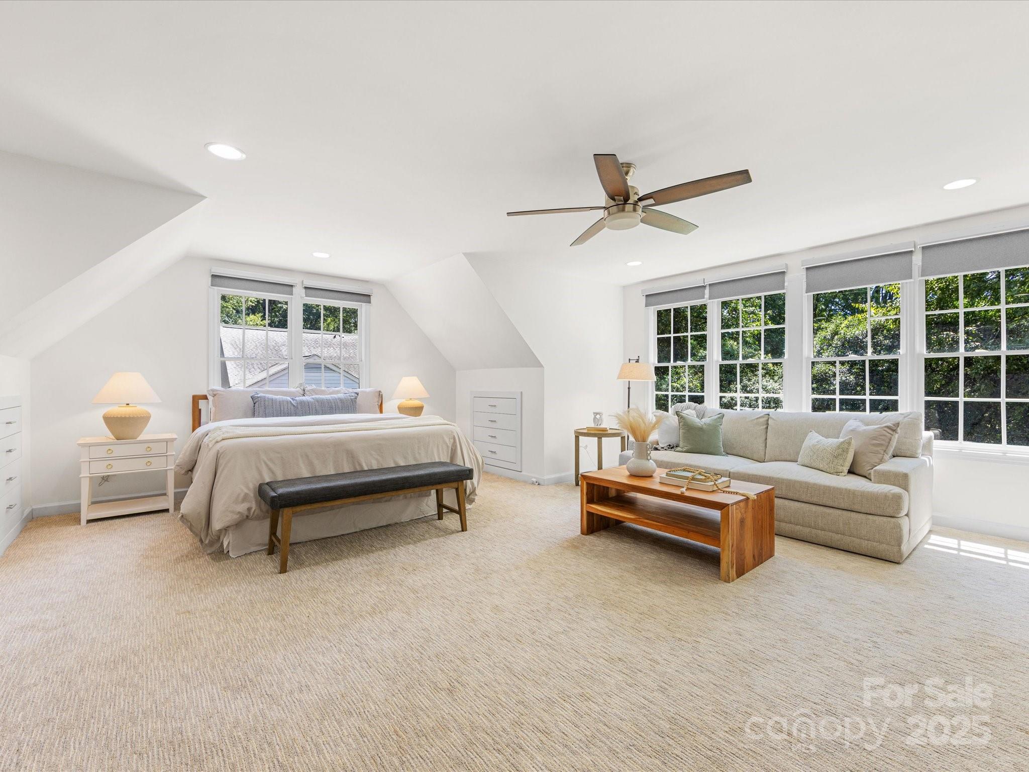 2118 Sharon Road Charlotte, NC 28207 - Photo 47 of 48 a spacious bedroom with a bed a couch and a chandelier