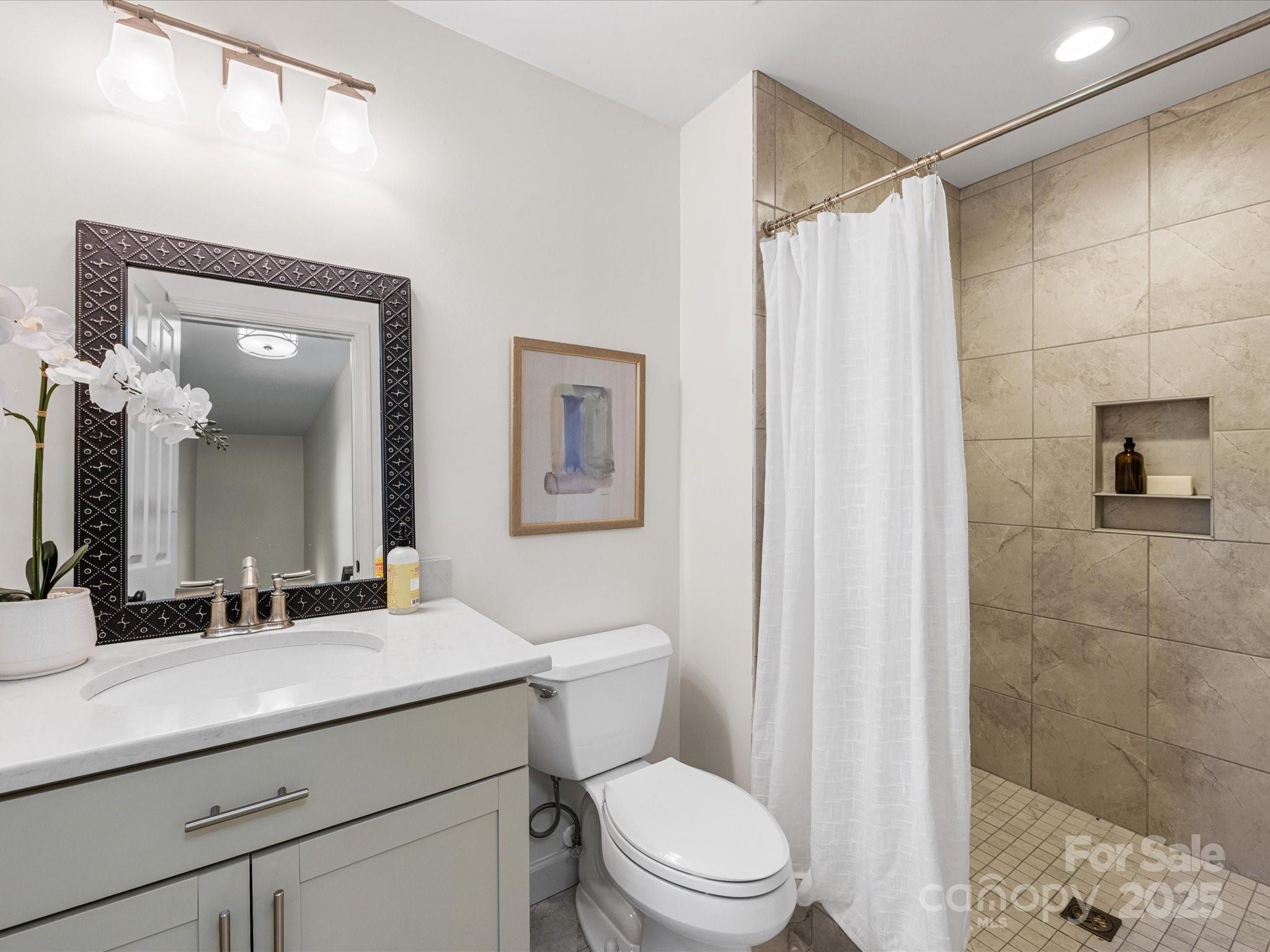 2118 Sharon Road Charlotte, NC 28207 - Photo 48 of 48 a bathroom with a sink a toilet a shower and a mirror